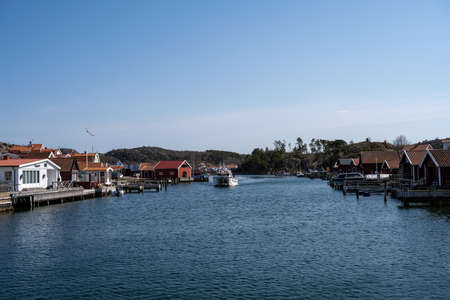 April 17, 2021 - Hamburgsund, Sweden: A picturesque fishing village on the Swedish West coast. Traditional red sea huts and a blue sky in the backgroundのeditorial素材