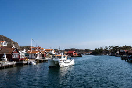 April 17, 2021 - Hamburgsund, Sweden: A picturesque fishing village on the Swedish West coast. Traditional red sea huts and a blue sky in the backgroundのeditorial素材