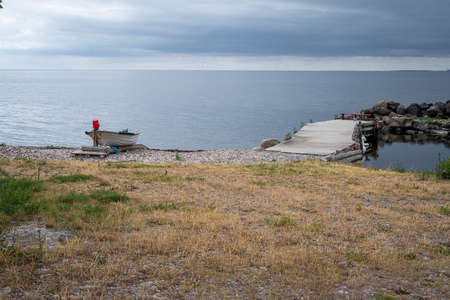 A boat on the seashore. Picture from the Baltic Sea. Blue sky and ocean in the background.の写真素材