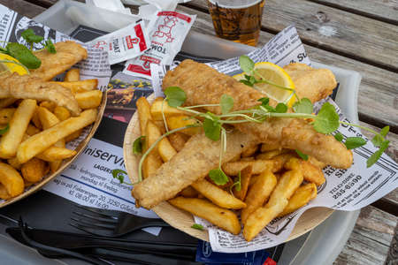 October 10, 2021 - Hundested, Denmark: A plate of delicious fish and chips. Business as usual in the restaurants in the marinaのeditorial素材