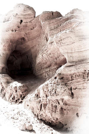 A weathered, bleached, rock with names carved into itの写真素材