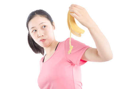 Wanna some? A starving sexy woman holding a half-peeled banana in her hand.の写真素材