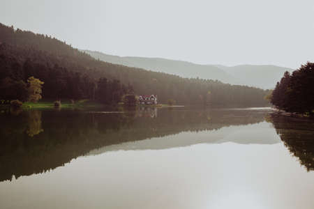 Beautiful landscape in autumn with mountains and trees reflecting on a calm lake like a mirror, Reflection on Bolu Lake TURKEYの写真素材
