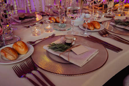 Close up shot of a luxury alfresco wedding reception table set up at the countryside; crystal...