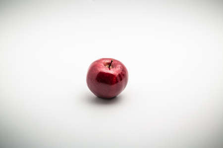 Close up shot of a red shiny dotted apple isolated on white background with copy spaceの写真素材