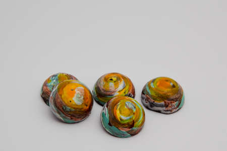 Staked colorful round milk chocolates that looks like planets isolated on white background with copy...