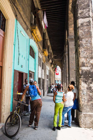 Havana / Cuba - 04.15.2015: Cuban men and women standing on the street chattingのeditorial素材