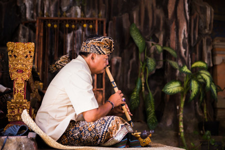 Bali - Indonesia - 10/22/2015: Indonesian musician dressed in traditional clothes playing the vertical bamboo fluteのeditorial素材