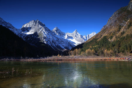 Mountain lake with snow and clear blue sky in autumn, Chinaの写真素材