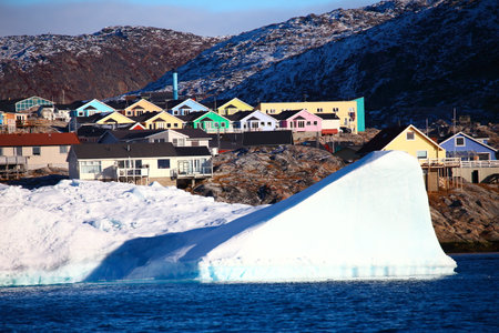 Antarctic landscape with icebergs and houses. Ilulissat, Greenland