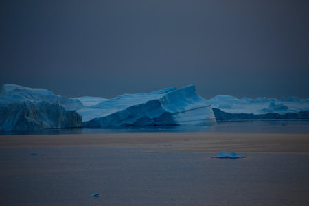 Antarctic landscape with icebergs and ice floes at night