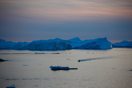 Antarctic landscape with icebergs and ice floats at sunset