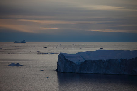 Antarctic landscape with icebergs and ice floats at sunsetの写真素材