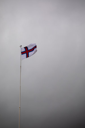 Norwegian flag waving in the wind against a cloudy gray sky.の写真素材