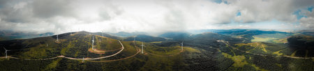Aerial panorama of wind turbines in the mountains on a cloudy day