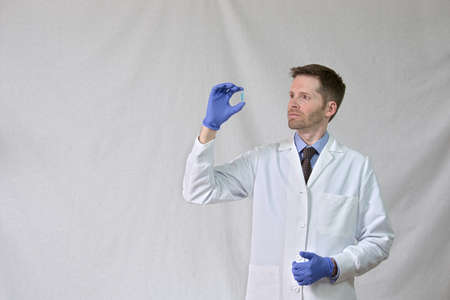 Scientist examining test tube with blue liquidの写真素材
