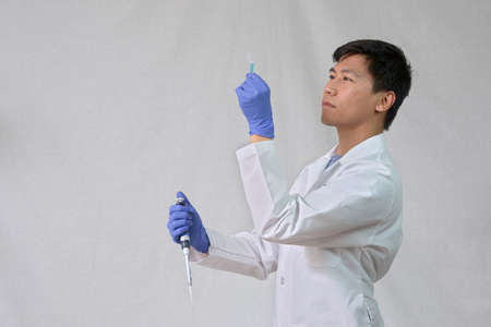 Scientist holding test tube and pipetの写真素材