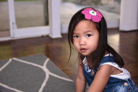 Female toddler kneeling on floorの写真素材