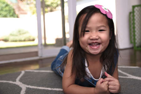 Female toddler smiling and laying on floorの写真素材