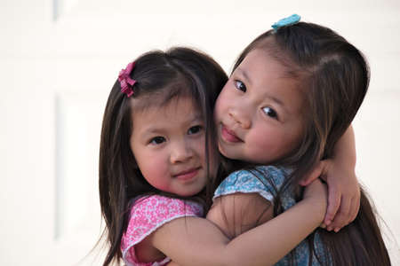 Asian sisters huggingの写真素材