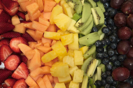 Sliced fruit arranged in rainbowの写真素材