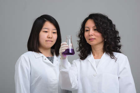 Two asian female scientists examining flaskの写真素材