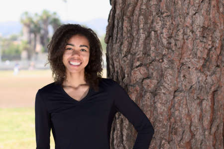 Young woman with curly hair posed outside
