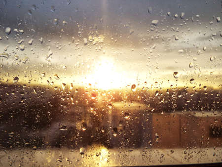 Rain drops on window and sun set