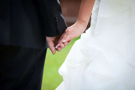 Young married couple holding hands on wedding day の写真素材