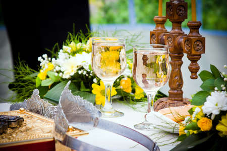 Wedding crowns, bible and wine glasses prepared for ceremonyの写真素材