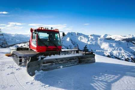 Snow-grooming machine on snow hill ready for skiing slope preparations in Austrian Alps の写真素材