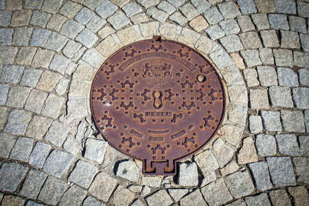 Budapest rusted sewer cap surrounded by pavement granite stones