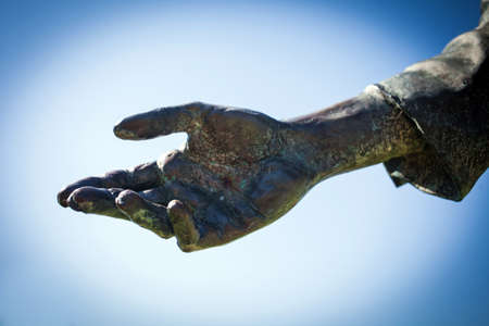 Open palm gesture of a bronze statueの写真素材