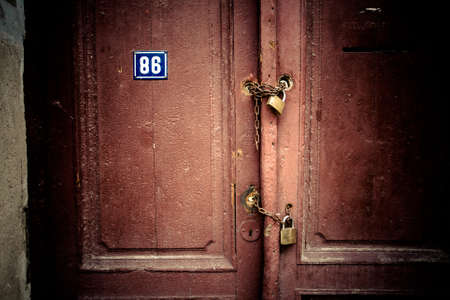Old rusty padlock and chain on the wooden gate homeの写真素材