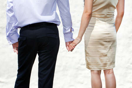 Young married couple holding hands on wedding day の写真素材