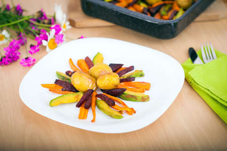 Plate ful of vegetable cooked with potato, beetroot, avocado and carrot chipsの写真素材