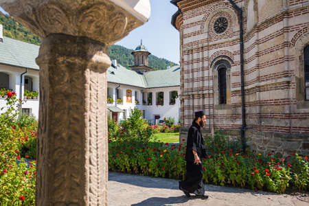 Cozia Romania  Septemper 2 2012: Priest walking inside Cozia monastery church housing the tomb of Mircea the Elder Romaniaのeditorial素材