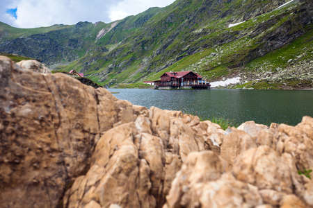 BALEA LAKE, ROMANIA - JUNE 24, 2012: Idyllic view with cottege on Balea Lake shore in Fagaras Mountains, Romania.のeditorial素材