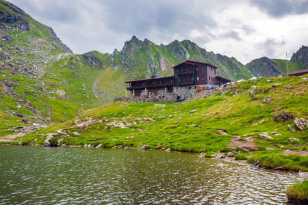 BALEA LAKE, ROMANIA - JUNE 24, 2012: Idyllic view with typical lodge on Balea Lake shore in Fagaras Mountains, Romania.のeditorial素材
