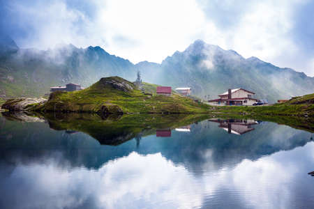 BALEA LAKE, ROMANIA - JUNE 24, 2012: Idyllic view with typical lodges on Balea Lake shore in Fagaras Mountains, Romania.のeditorial素材