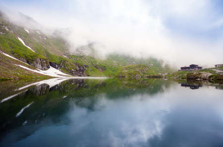 BALEA LAKE, ROMANIA - JUNE 24, 2012: Idyllic view with typical lodge on Balea Lake shore in Fagaras Mountains, Romania.のeditorial素材