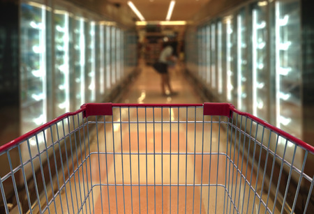 Shopping cart view in Supermarket Aisle with product shelves in blurry for background.の写真素材