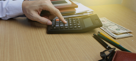 Man using calculator in home office.の写真素材