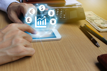 Businessman use smartphone with Currencies sign symbol of Fintech over the Network connection on the...