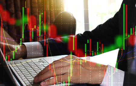 Double exposure of businessman using the laptop with stock market or financial graph for financial...
