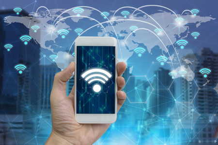 Businessman hand use smartphone with wifi icons connection and network communication on map world.の写真素材