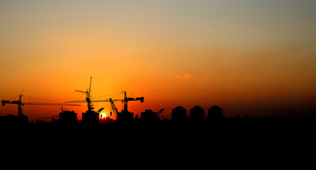 Silhouette crane construction building at sunset, Industrial crane construction