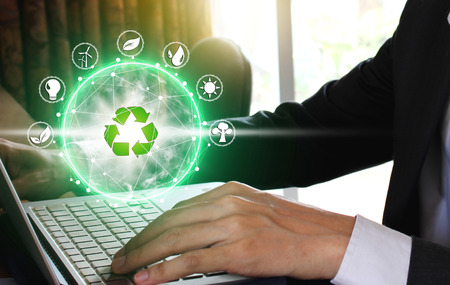 Hand use laptop computer with environment Icons over the Network connection on nature background,...