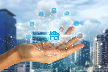 Hand holding with property investment icons over the Network connection on property background, Property investment concept.の写真素材