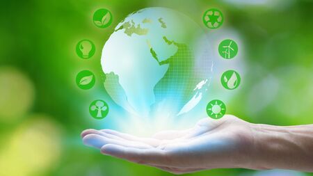 Hand holding with earth and environment icons over the Network connection on nature background,...